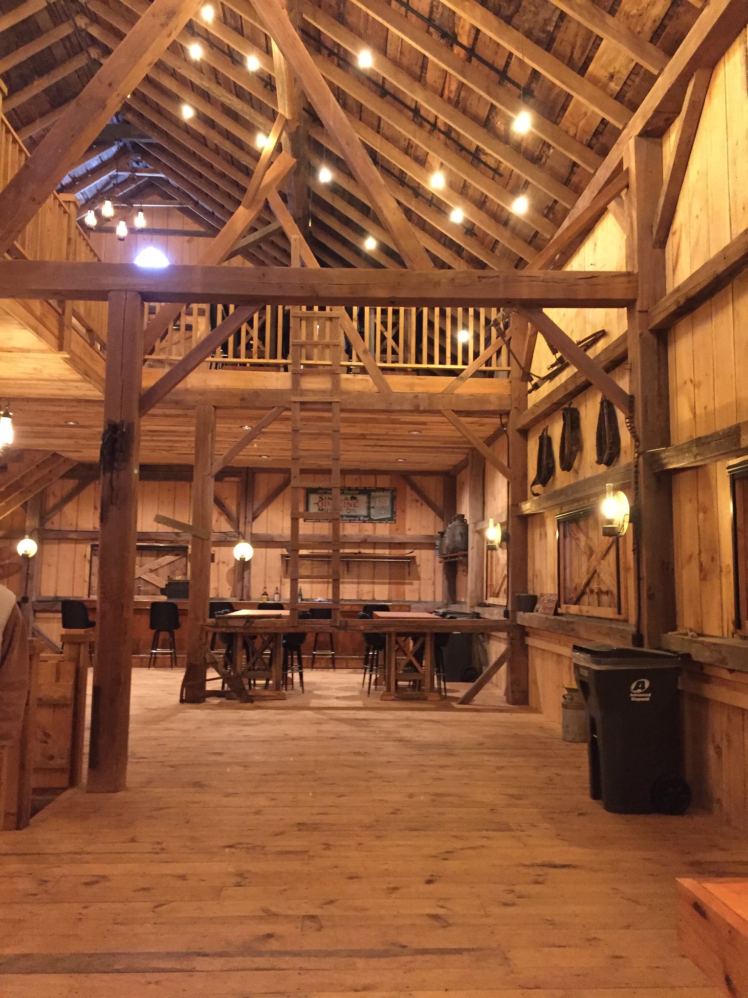 The interior of a barn with a mezzanine floor and a table and chairs